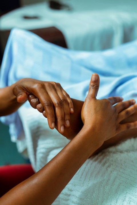 a person holding another persons hand in a hospital bed