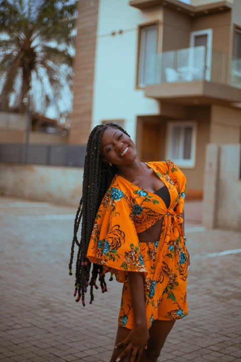 a woman with dreadlocks standing in front of a building oq0xrZnI