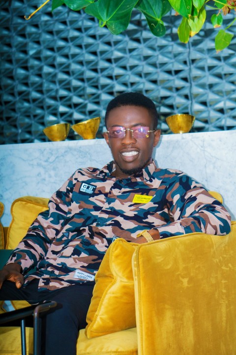 man in black and white camouflage jacket sitting on yellow chair