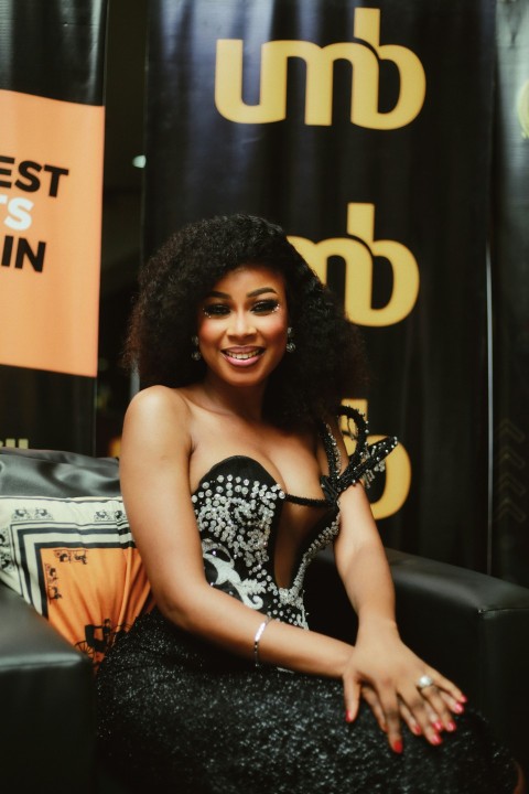 a woman in a black and white dress sitting on a couch