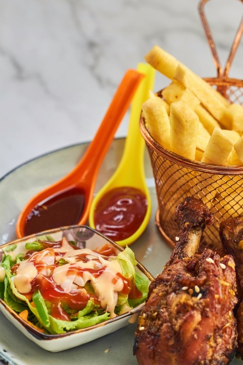 a plate of food with a basket of fries and a bowl of ketchup