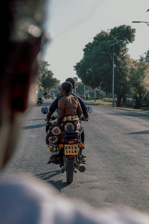 man in black and yellow floral shirt riding motorcycle on road during daytime Na