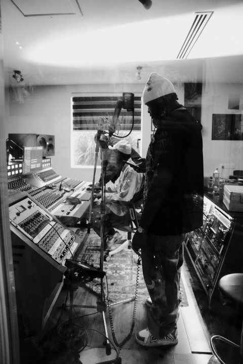 a man standing in front of a microphone in a recording studio