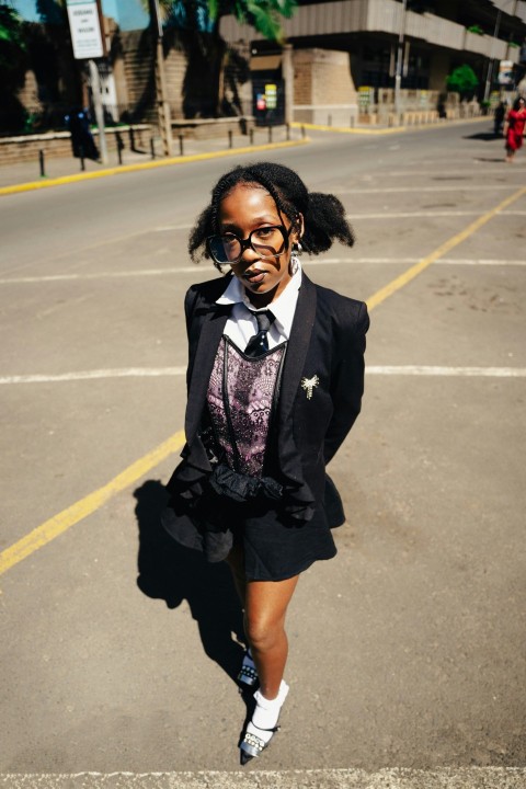 a woman in a suit and tie walking down a street fcn