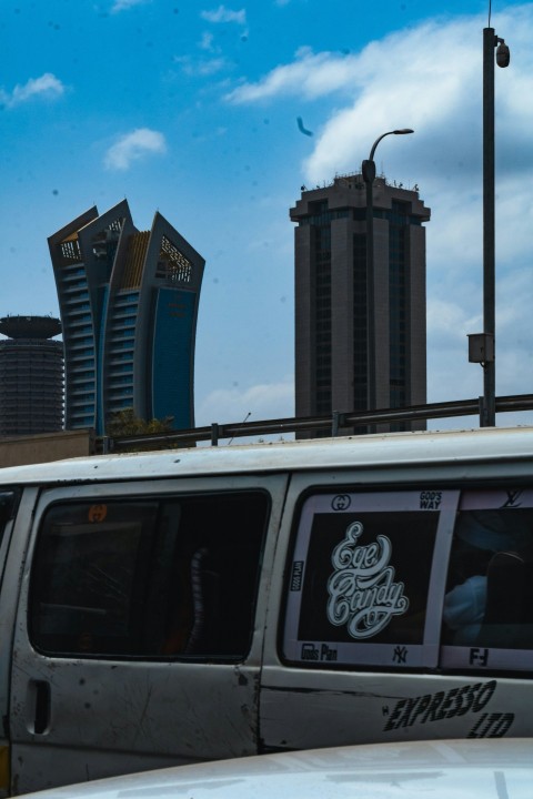 a white van parked in front of a tall building d3QxW