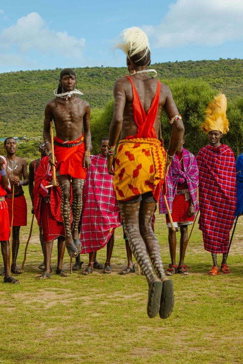 a group of people standing on top of a lush green field