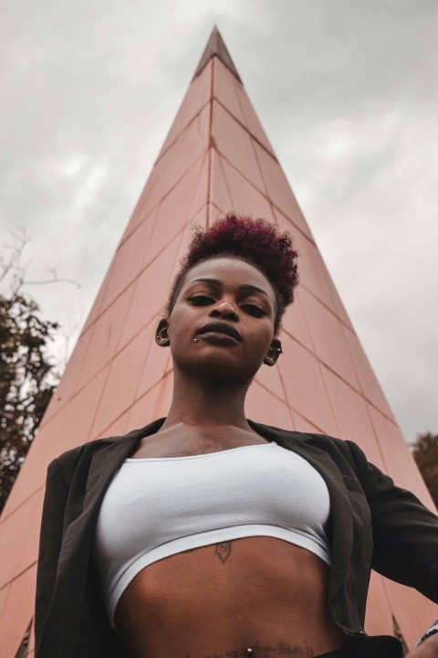 woman in black jacket standing near brown concrete building during daytime jEPigqfM