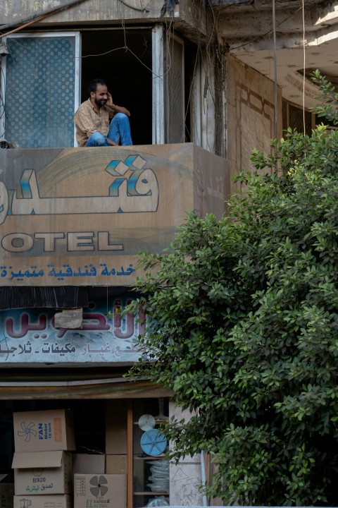 woman in blue dress standing in front of brown concrete building during daytime m