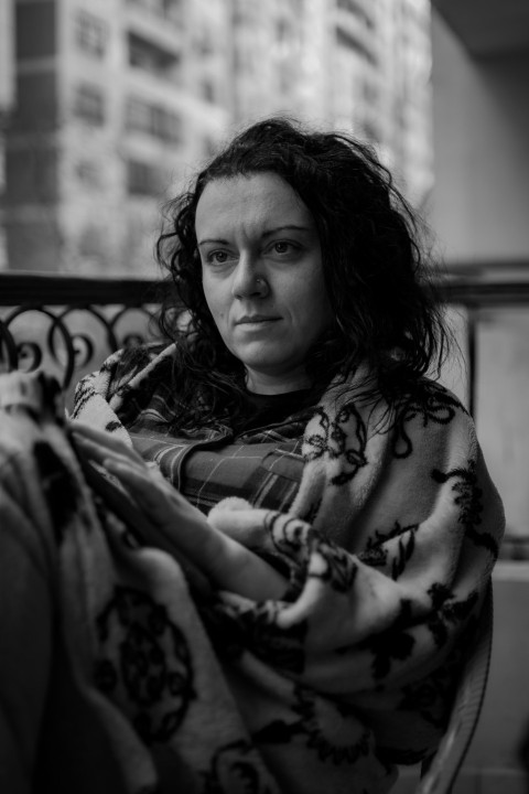 a black and white photo of a woman wrapped in a blanket