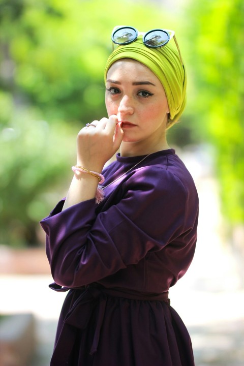 woman wearing purple long sleeved top holding her lips during daytime