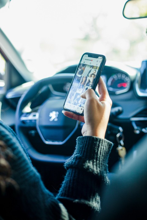 a person using a cell phone while driving a car D7aDt8