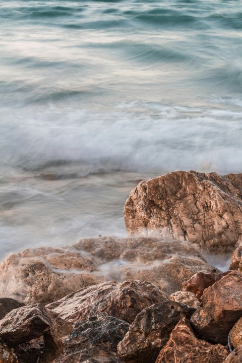 brown rock formation near body of water during daytime