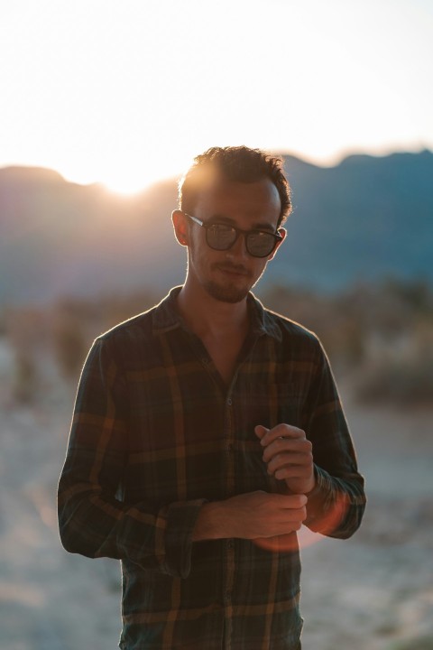 man in brown and black plaid dress shirt wearing black framed eyeglasses