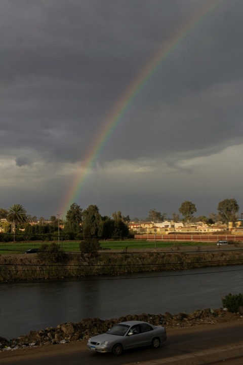 a car driving down a road with a rainbow in the background kt1B6