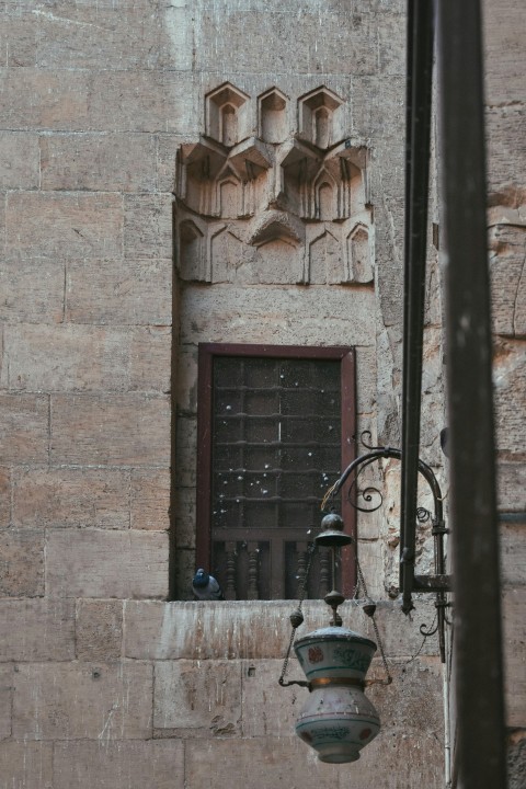 a lamp hanging from the side of a building e9yQXKWB