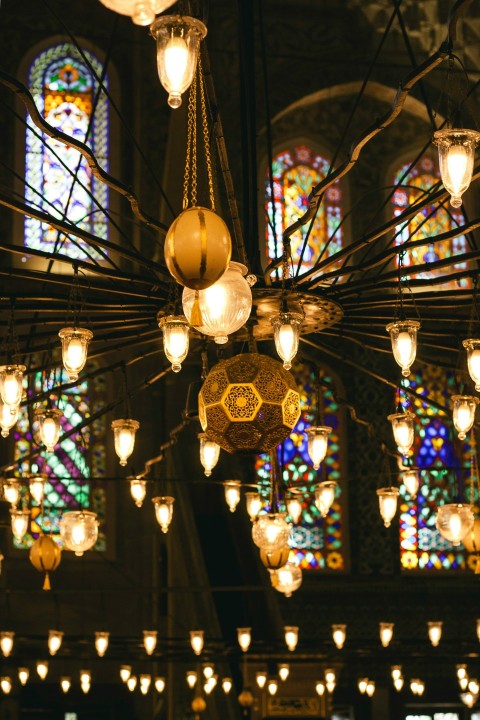 a chandelier hanging from a ceiling in front of a stained glass window