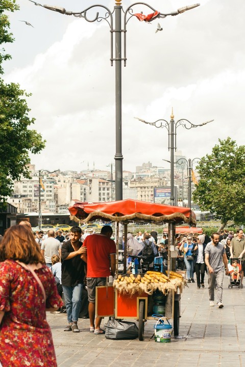 a group of people walking down a street next to a street light