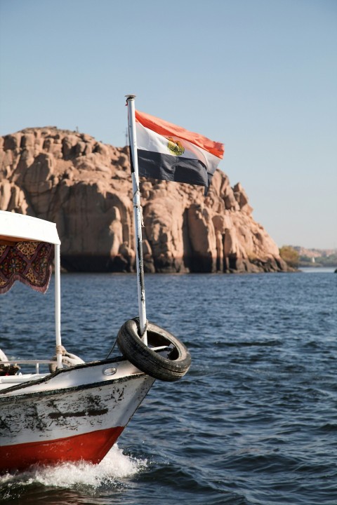 a boat in the water with a flag on top of it x7A5Za