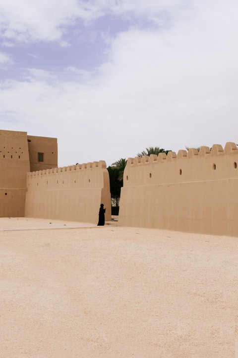 person wearing black clothes near beige wall during daytime zNkbGmb