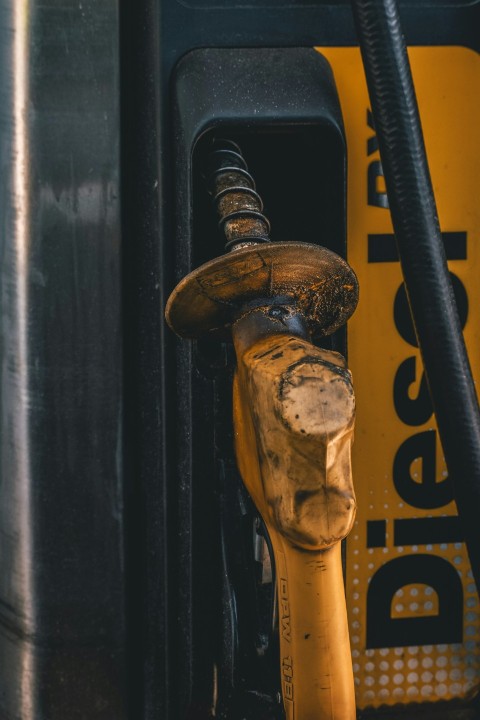 closeup photography of yellow and black gasoline pump during daytime