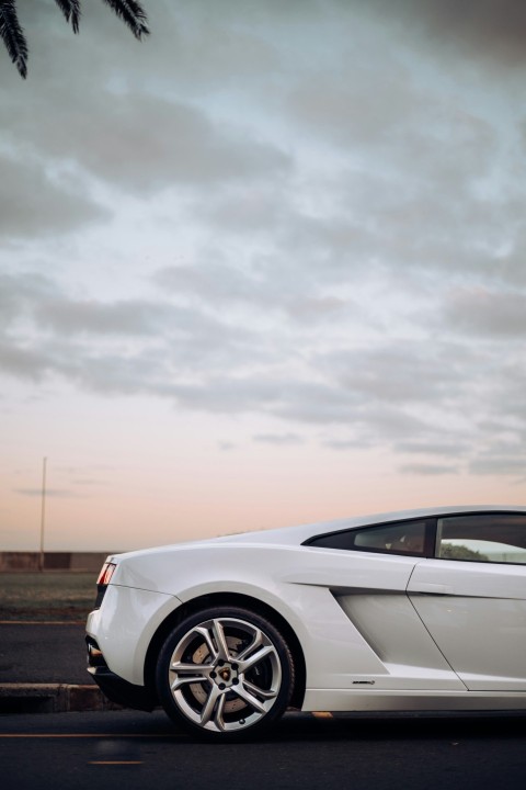 a white sports car parked on the side of the road