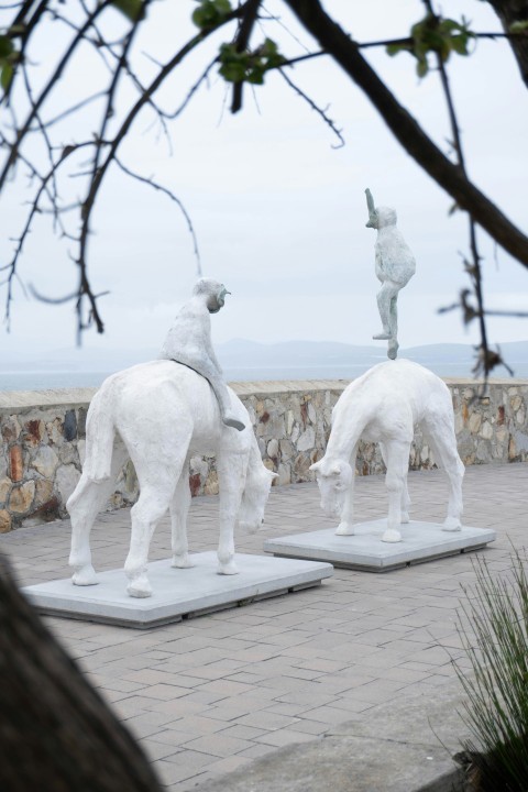 a couple of white statues sitting on top of cement blocks