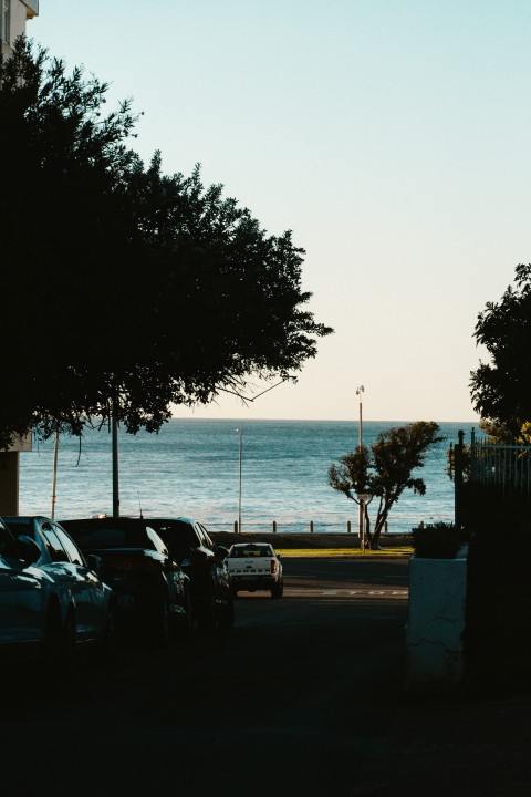 cars parked on the side of the road near the ocean km2EfnqD