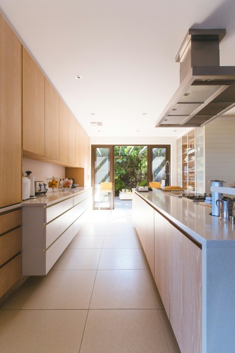 white wooden kitchen island and cupboard cabinets near glass panel door AQl