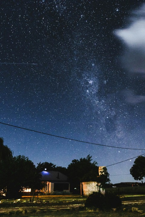 the night sky with stars above a house