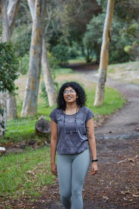 a woman standing on a path in the woods