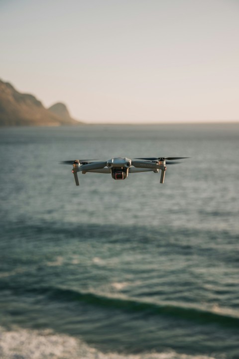 white and black drone flying over the sea during daytime 7