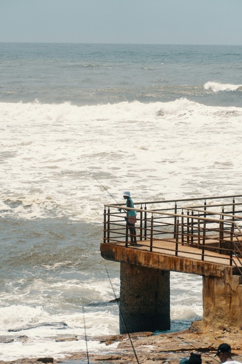 a man standing on a bridge over a body of water