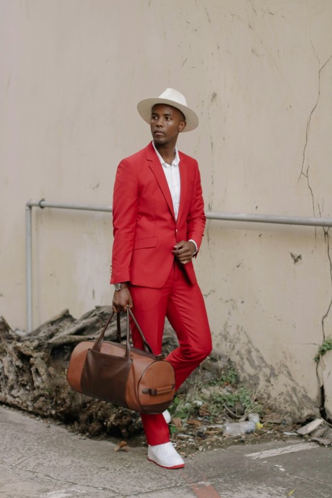 a man in a red suit holding a brown bag