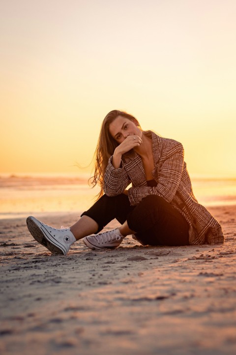 a woman sitting on the beach at sunset  j7h20