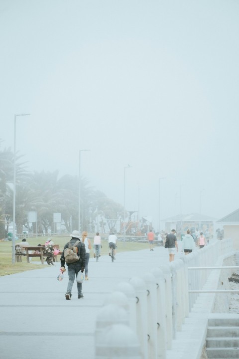 a group of people walking down a sidewalk in the snow