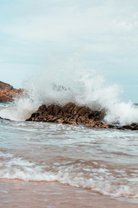 a wave crashing on a rock in the ocean 10cBHAa