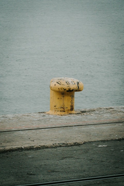 a yellow fire hydrant sitting on the side of a road