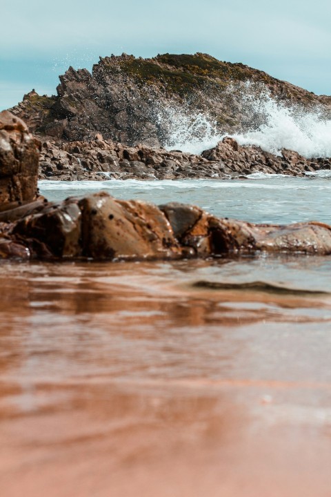 a large wave crashing into a rocky shore i