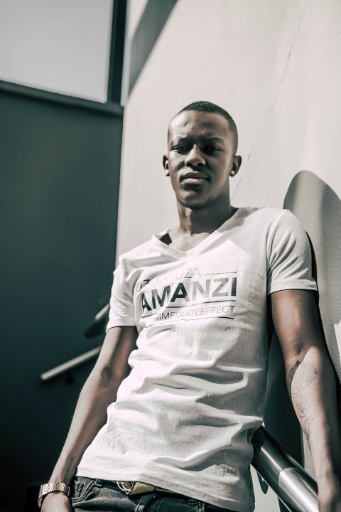 man in white crew neck t shirt sitting on gray chair