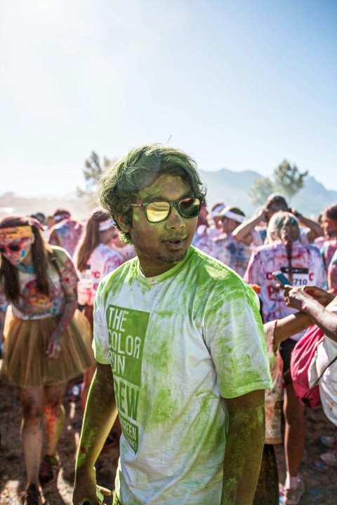 man in green crew neck t shirt wearing sunglasses standing near people during daytime FO9gmy