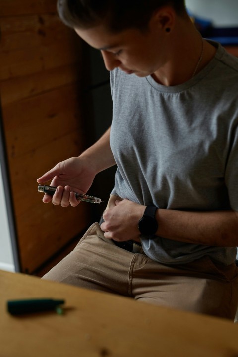 a person injecting insulin into stomach for diabetes management