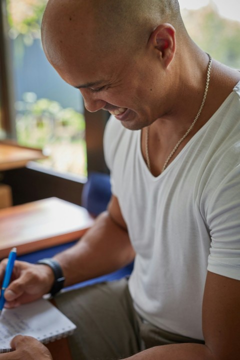 a man sitting at a desk writing on a piece of paper