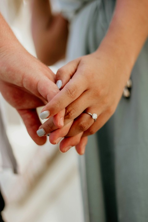 a close up of two people holding hands