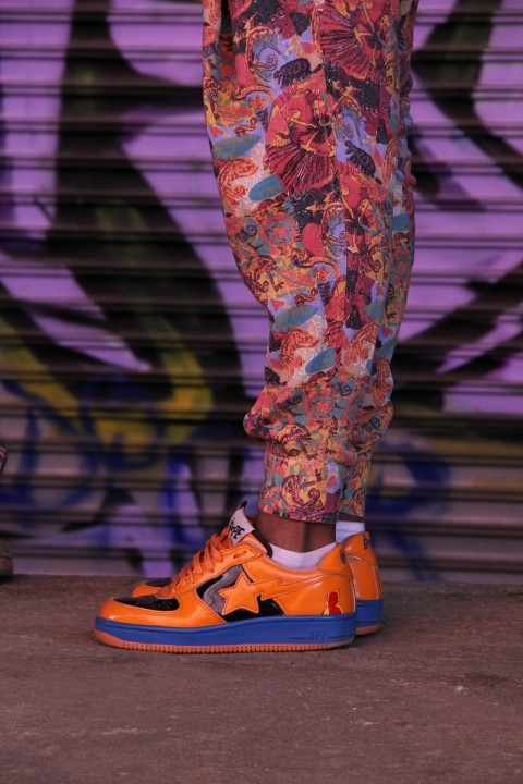 person wearing orange and blue low top sneakers