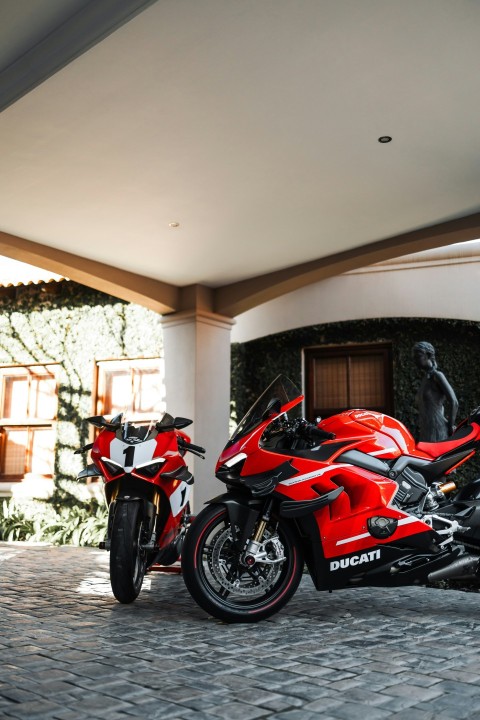 a red motorcycle parked in front of a building