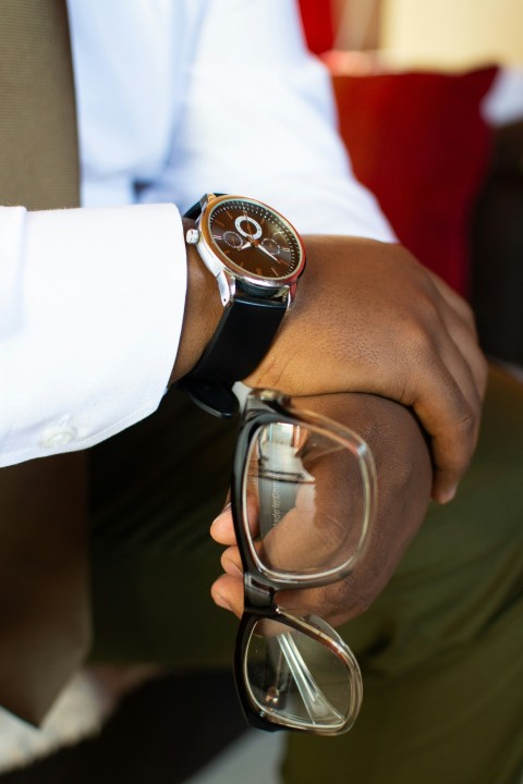 person in white dress shirt holding eyeglasses