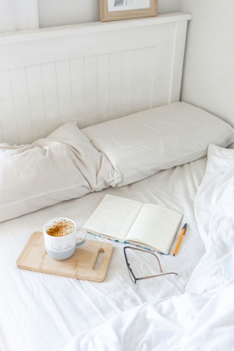 white ceramic mug on brown wooden tray beside white book