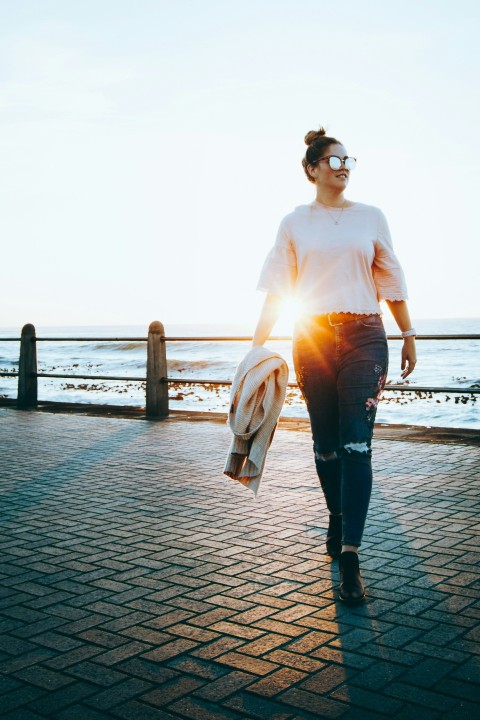 woman in white long sleeve shirt and black pants standing on dock during daytime