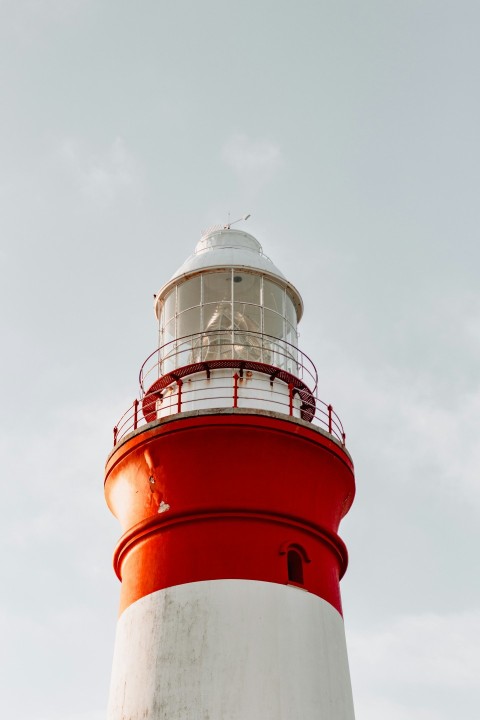 low angle photography of white and red lighthouse during daytime 9WsxH
