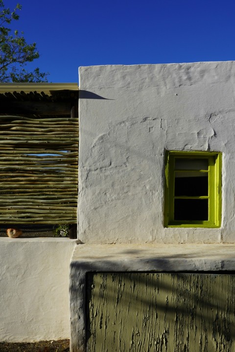 a white building with a green door and window